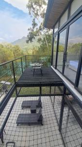 a deck with a bench on a balcony at Cabaña Piamonte Villeta in Villeta