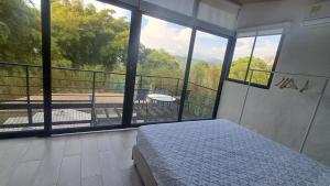 a bedroom with a bed and a balcony with a view at Cabaña Piamonte Villeta in Villeta +17 photos