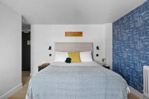 a bedroom with a large bed with a yellow pillow at Vigilance Suite - Free Wi-Fi - Sea View in Brixham