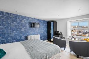 a bedroom with a bed and a blue wall at Vigilance Suite - Free Wi-Fi - Sea View in Brixham