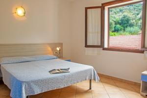 a bedroom with a bed and a large window at Residence Villa Franca in Capoliveri