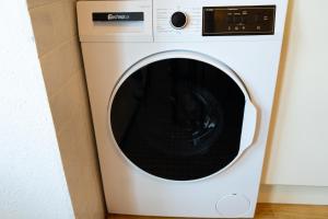 a white washing machine sitting in a room at Space Comfort Bremen Apartment bis zu 6 Personen in Bremen +14 photos