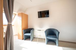 two blue chairs and a table in a room at Space Comfort Bremen Apartment bis zu 6 Personen in Bremen