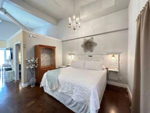 a bedroom with a white bed and a chandelier at Haven at Hazel~Downtown Bungalow in Demorest