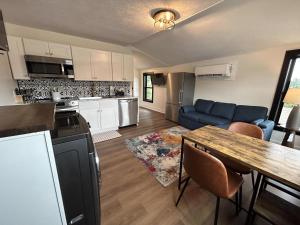 a kitchen and living room with a table and a blue couch at Victorian Queen Getaway Unit C Washerdryer in Muskegon
