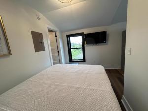 a bedroom with a bed and a window at Victorian Queen Getaway Unit C Washerdryer in Muskegon