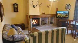 a living room with a couch and a fireplace at Complejo Turístico Fuenmayor in Torres