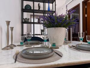 a table with plates and glasses and a vase with flowers at Tri-Zen Luxury Apartment Colombo, Tower 02, 20F, A2 in Colombo