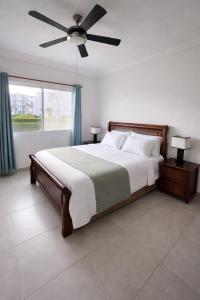 a bedroom with a large bed with a ceiling fan at Sol Tropical apartamentos in Punta Cana +15 photos