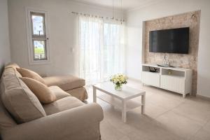 a living room with a couch and a tv at Sol Tropical apartamentos in Punta Cana