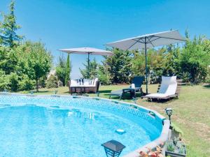 a swimming pool with chairs and umbrellas in a yard at Mountain pool house in Varnávas