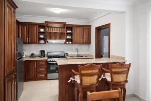 a kitchen with wooden cabinets and a counter top at Sol Tropical apartamentos in Punta Cana