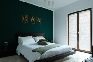 a bedroom with green walls and a large bed at Suite 64 in Saviano