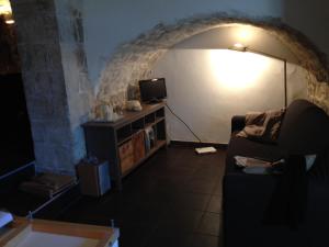 モーディカにあるLa Casa sulle Grotteのリビングルーム(ソファ付)、壁に照明が備わります。