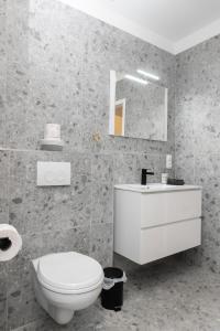 a bathroom with a white toilet and a sink at Infinity Stay Apartmenthaus am Park in Wilhelmshaven +111 photos