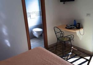 a bedroom with a table and a chair and a toilet at B&b La Vigna in Furore