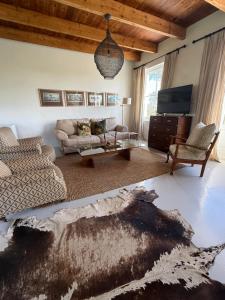 a living room with a couch and a tv at Firgrove Country Lodge in Robertson