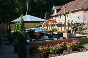 a patio with chairs and an umbrella and a pool at ZEcamping 3 étoiles chiens acceptés animations piscine chauffée in Grand-Laviers