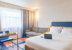 a hotel room with a bed and a couch at B&B HOTEL Lyon Nord 4 étoiles in Dardilly