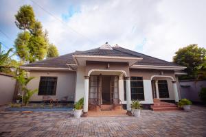 a small white house with a brick driveway at Lasai casa in Arusha