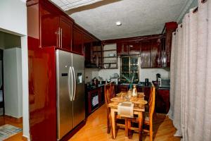 a kitchen with a stainless steel refrigerator and a wooden table at Lasai casa in Arusha