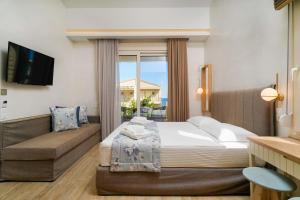 a hotel room with a bed and a couch at ILIORAMA LUXURY SUITES in Skala Potamias +75 photos