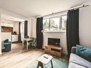a living room with a couch and a tv and a table at Infinity Stay Apartmenthaus am Park in Wilhelmshaven