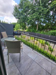 a patio with a table and chairs and a fence at Infinity Stay Apartmenthaus am Park in Wilhelmshaven