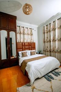 a bedroom with a large bed and a mirror at Lasai casa in Arusha