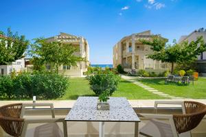 a table with a vase on it with two chairs at ILIORAMA LUXURY SUITES in Skala Potamias