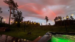 a hot tub in a yard with a rainbow in the sky at Luxury Resort Orava in Orava