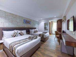 a hotel room with two beds and a desk at Blue Orange Hotel and Towers in Shomolu