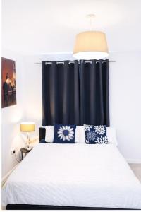 a bedroom with a bed with a black curtain at Wilsuel Haven-2Bedroom Aprt in Wolverhampton