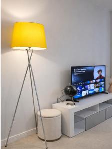a yellow lamp in a living room with a tv at Wilsuel Haven-2Bedroom Aprt in Wolverhampton