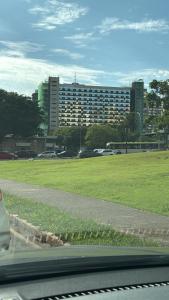 a field of grass with a large building in the background at Flat - Excelente localização - Hotel Garvey in Brasília