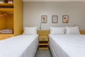 two beds sitting next to each other in a room at Flat - Excelente localização - Hotel Garvey in Brasília
