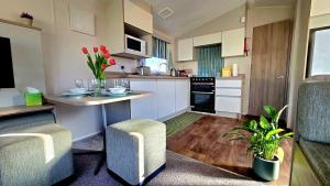 a kitchen with a table and two chairs and a counter at Tea & Toast Cottage Seton Sands in Port Seton +16 photos