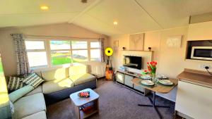 a living room with a couch and a table at Tea & Toast Cottage Seton Sands in Port Seton