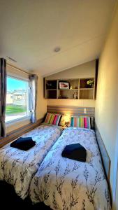 a bedroom with two beds and a window at Tea & Toast Cottage Seton Sands in Port Seton