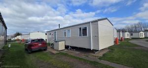 a car parked in front of a tiny house at Tea & Toast Cottage Seton Sands in Port Seton