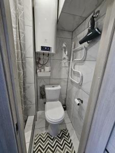 a small bathroom with a toilet and a shower at Studio apartment in Rēzekne