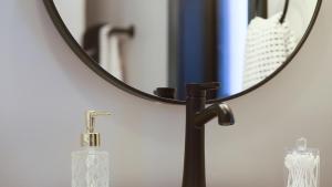a mirror sitting on top of a bathroom sink at Modern Queen Apartment At The Victorian Unit E in Muskegon +17 photos