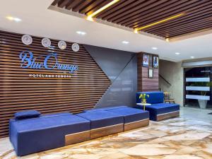 a lobby with blue couches and a sign on the wall at Blue Orange Hotel and Towers in Shomolu