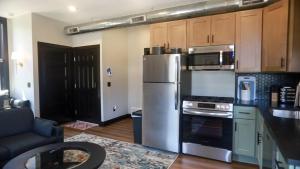 a kitchen with a stainless steel refrigerator and a stove at Modern Queen Apartment At The Victorian Unit E in Muskegon