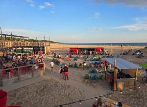 a group of people sitting on the beach at Modern Queen Apartment At The Victorian Unit E in Muskegon
