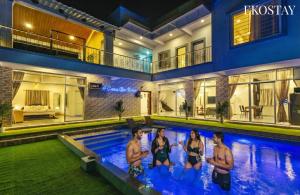 a group of people in the swimming pool of a house at EKOSTAY - Casa De Reva in Lonavala