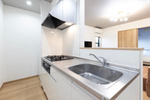 a kitchen with a sink and a stove at Bio Top Apartment Stay in Fukuoka