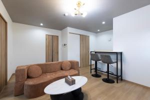a living room with a couch and a table at Bio Top Apartment Stay in Fukuoka