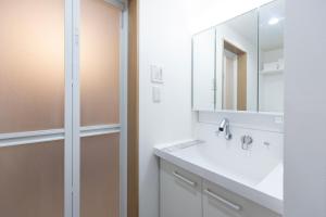 a white bathroom with a sink and a mirror at Bio Top Apartment Stay in Fukuoka +11 photos