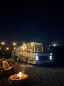 a bus is parked in front of a fire at Refúgio Da Lua - Buss motorhome in Ametista do Sul +6 photos